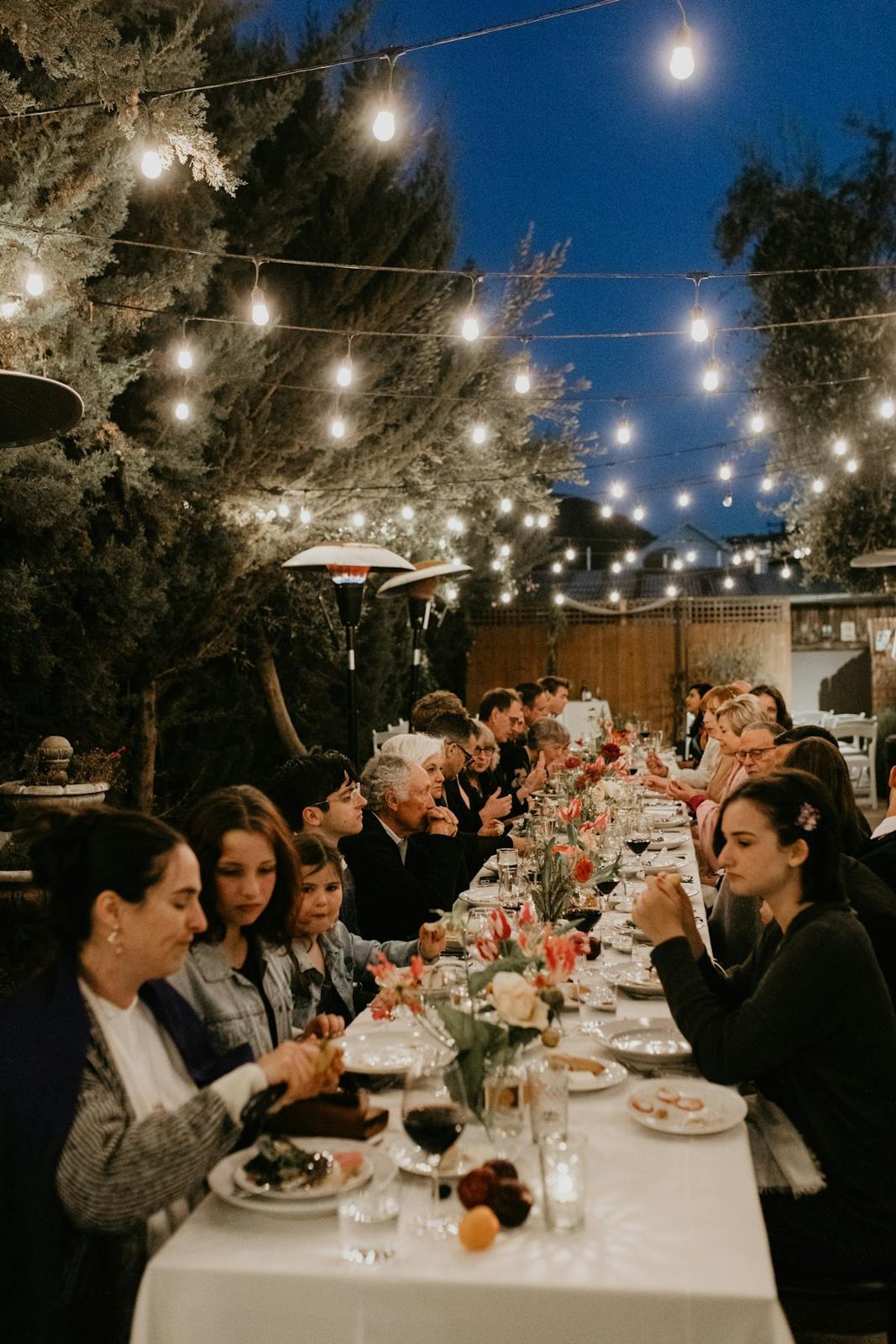 Courtyard long table set under string lights beside the fountain
